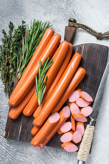 German raw Frankfurter sausages on a wooden board. White background. Top view.