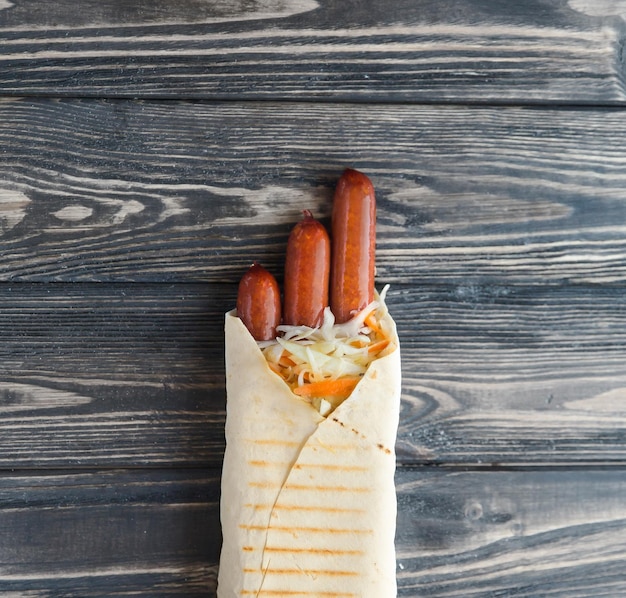 German sausages in pita bread on a dark wooden backgroundphoto with copy space