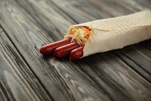 German sausages in pita bread on a dark wooden backgroundphoto with copy space