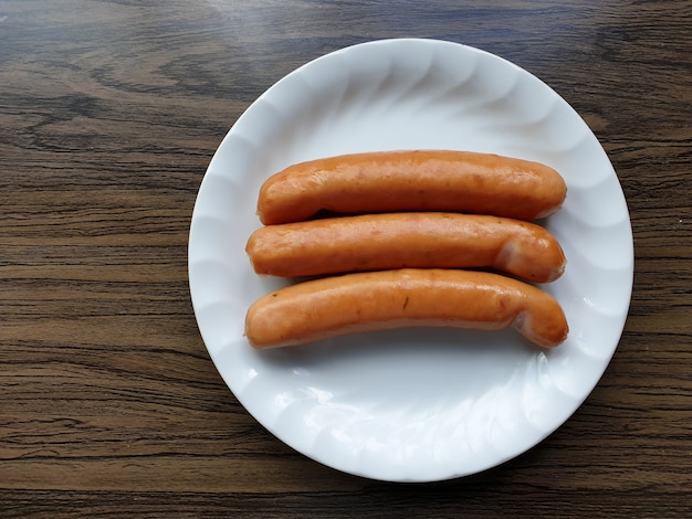 German sausages in a white dish on wooden background