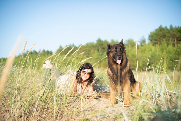 german shepherd dog and woman on beach background