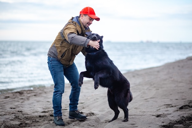 German Shepherd and its owner walk along shore of Black Sea, Poti