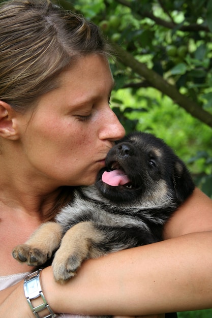 女性とジャーマンシェパードの子犬