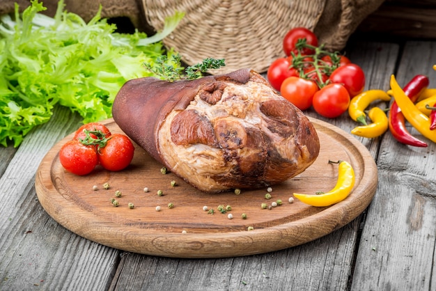 Gerookt hamsprong met kruiden en specerijen op houten plaat.