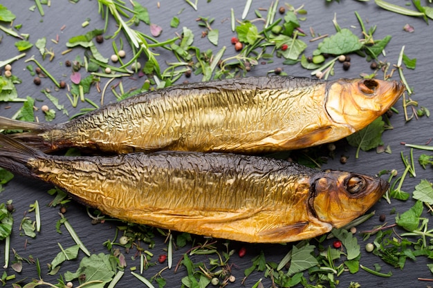 Gerookte forel met kruiden op een stenen dienblad.