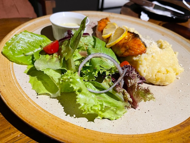 Gerookte gegrilde zalmvis geserveerd met salade en aardappelpuree met citroenen