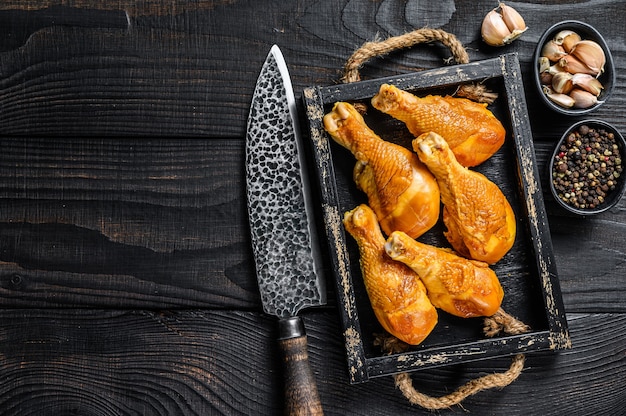 Gerookte kippenpootdrumsticks met kruiden en specerijen op houten tafel. Bovenaanzicht.