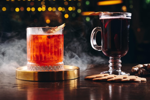 Foto gerookte ouderwetse cocktail en glühwein op tafel op donkere achtergrond