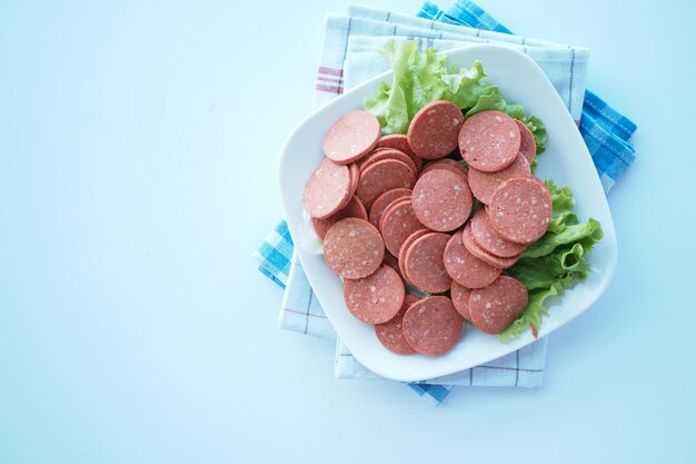 Gerookte salamiworst op een bord op witte achtergrond