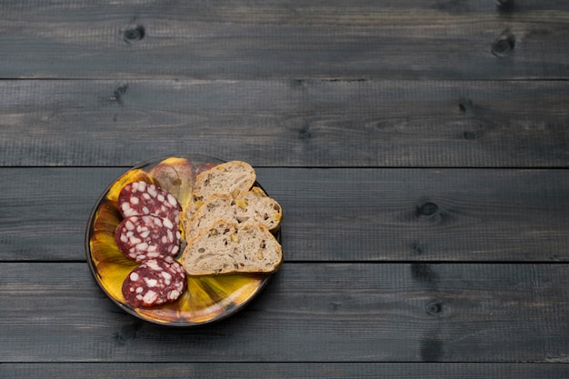 Gerookte worst met notenbrood op een kleiplaat.