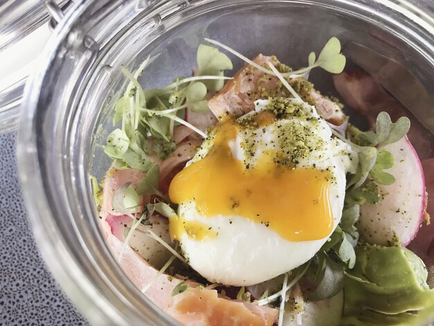 Gerookte zalm met gepocheerd ei en avocado in een pot