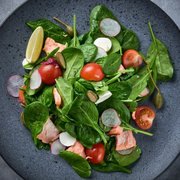 Gerookte Zalmsalade. Gezond eten Lekkere salade met rode vis, radijs en kerstomaatjes. Bovenaanzicht. Detailopname.