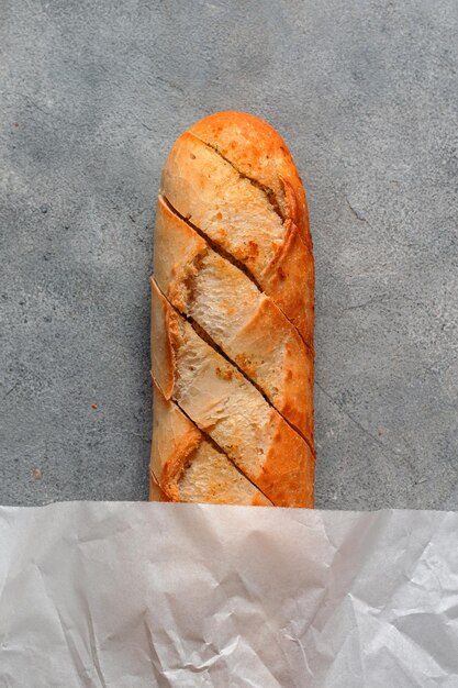 Geroosterd gesneden knoflookbrood stokbrood met papper zak op grijze stenen achtergrond bakkerij conceptxA