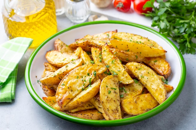 Geroosterde aardappelpartjes met kruiden en zeezout op plaat, bovenaanzicht (Turkse naam; elma dilim patates)