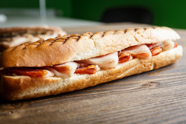 Geroosterde baguettesandwich met ham op een houten ondergrond