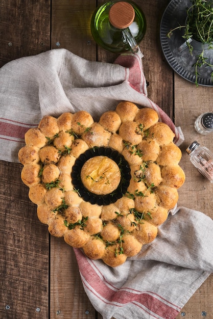 Geroosterde camembert kaas en zelfgebakken brood hartvormig en tijm op rustieke achtergrond. Franse kaas. Concept van romantische liefde voor Valentijnsdag. Bovenaanzicht, kopieer ruimte.