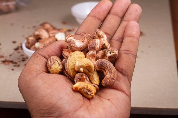 Geroosterde cashewnoten in de hand op een lichte achtergrondisolatie