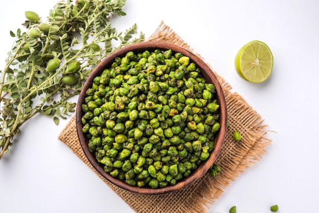 Geroosterde groene kikkererwten of Bhuna harbara geserveerd in een kom, over een humeurige achtergrond, selectieve focus