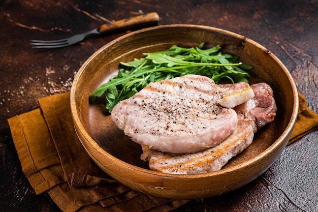 Geroosterde karbonadesteaks of schnitzels met rucolasalade Donkere achtergrond Bovenaanzicht