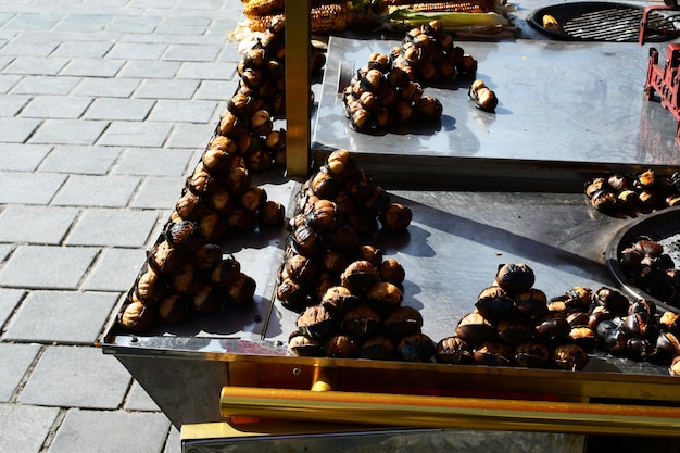 Foto geroosterde kastanjes op een straatteller verkoop van geroosterde kastanjes op de stadsstraat