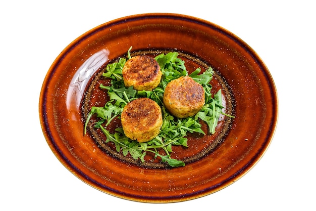 Geroosterde kikkererwten falafel pasteitjes met rucola op een bord geïsoleerd op een witte achtergrond