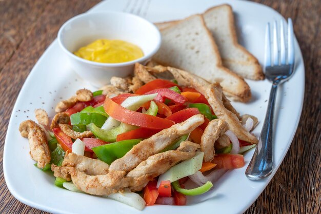 Geroosterde kipfilet met groenten en brood op een witte plaat close-up