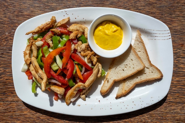 Geroosterde kipfilet met groenten en brood op een witte plaat close-up