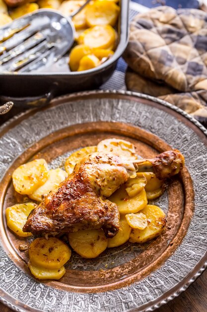 Geroosterde kippenpoot met aardappelen met karwij en knoflook.