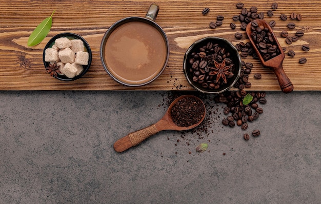 Geroosterde koffiebonen met koffiekopopstelling op donkere steenachtergrond