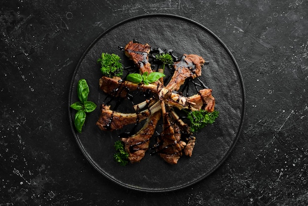 Geroosterde lamsribben met kruiden en knoflook op een donkere keukentafel Rustieke stijl Foto voor de catalogus