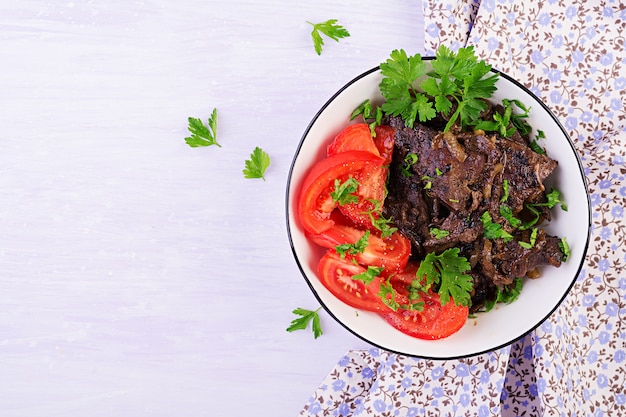 Geroosterde of geroosterde rundvleeslever met ui en tomatensalade, keuken van het middenoosten, hoogste mening