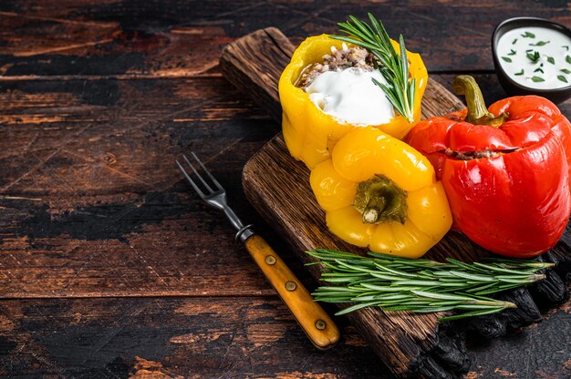 Geroosterde paprika gevuld met rundvlees, rijst en groenten op een houten plank