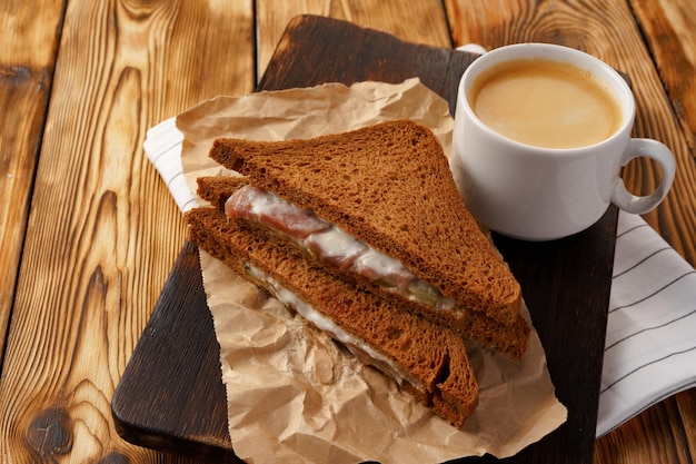 Geroosterde rogge sandwich met ham in twee helften gesneden op tafel close-up