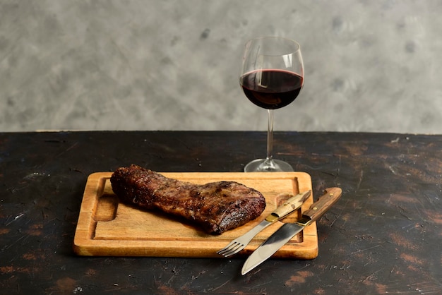 Geroosterde rundvleesribben met een glas rode wijn gepresenteerd op de tafel traditionele Argentijnse keuken