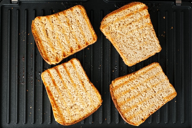 Foto geroosterde sneetjes brood op een elektrische grill met strepen.