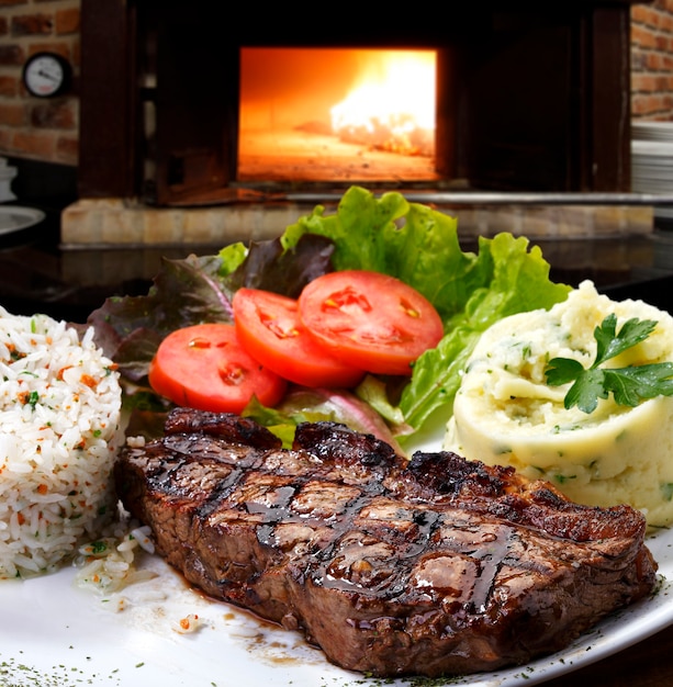 Geroosterde steak met garnituur groenten aardappelen rijst