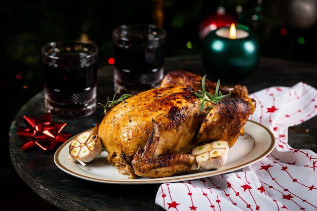 Geroosterde Turkije kersttafel geserveerd met kip versierd met kerstdecor en kaarsen Geroosterde kip tafelsetting Kerstdiner Nieuwjaarsdiner