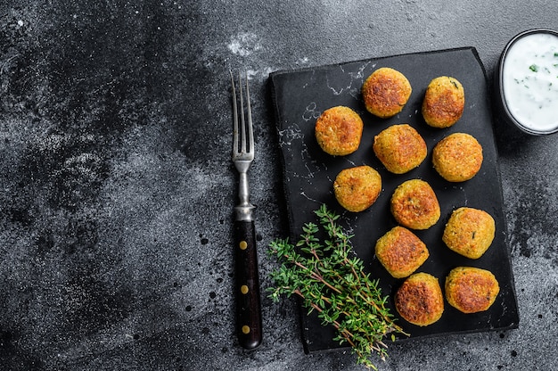 Foto geroosterde vegetarische falafelballetjes van gekruide kikkererwten met knoflookyoghurtsaus.