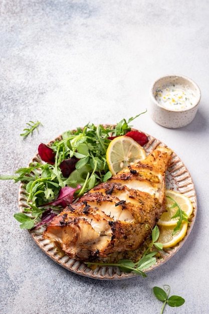 Geroosterde zeebaarsvissen en groene salade