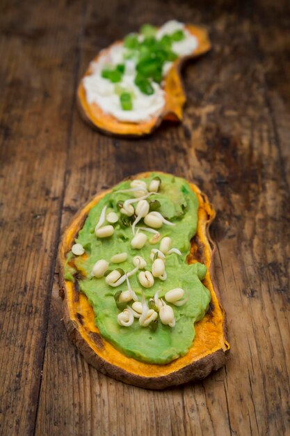 Geroosterde zoete aardappelplak gegarneerd met avocadocrème en spruitjes