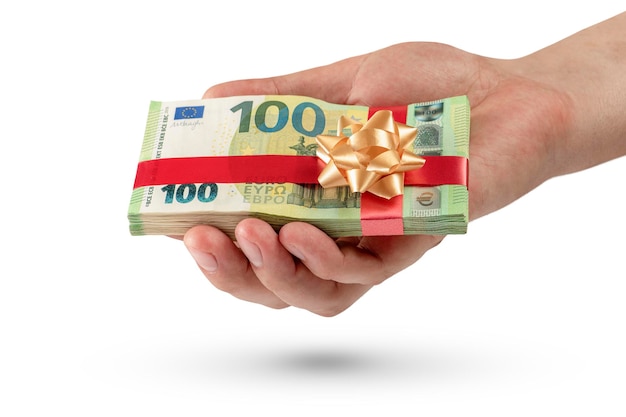 Geschenk van geld Een pakje van 100 euro biljetten in een mannenhand is geïsoleerd op een witte achtergrond Geld cadeau concept voor verjaardag of kerst