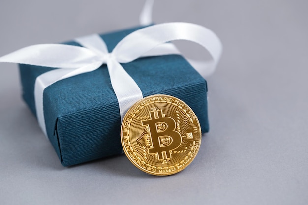 Geschenkdoos blauwe kleur gouden bitcoin op grijze achtergrond Cadeau voor mannen concept