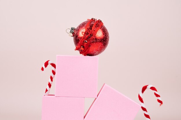 Geschenkdoos en zuurstokken in de sneeuw op roze oppervlak. Feestelijke achtergrond. Hoge kwaliteit foto