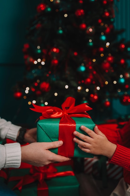 Geschenkdoos in de handen van moeder en zoon Kerststemming