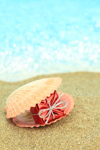 Geschenkdoos in een zeeschelp op het strand