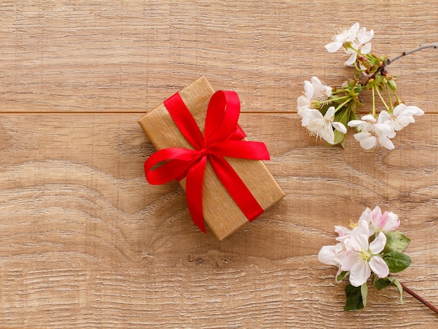 Geschenkdoos met bloeiende takken van kersen- en appelbomen op de houten achtergrond bovenaanzicht