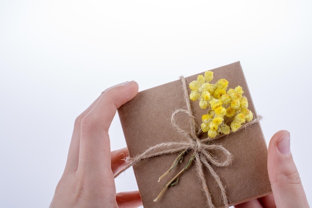 Geschenkdoos met bloemen in de hand