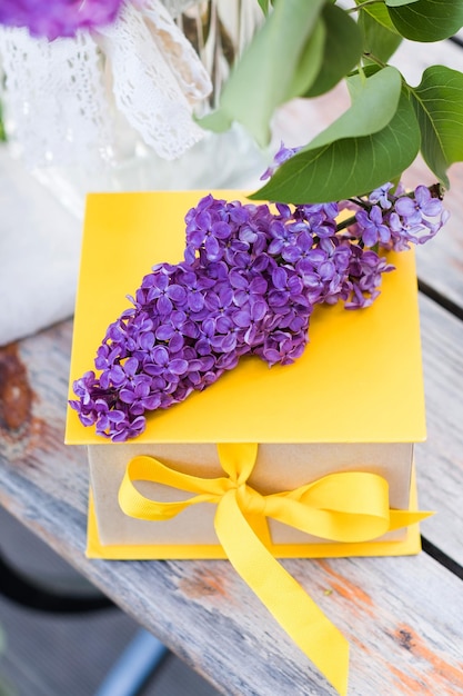 Geschenkdoos met geel lint en lila boeketten Een wenskaart