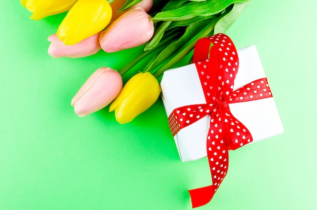 Geschenkdoos met rood lint en tulpen