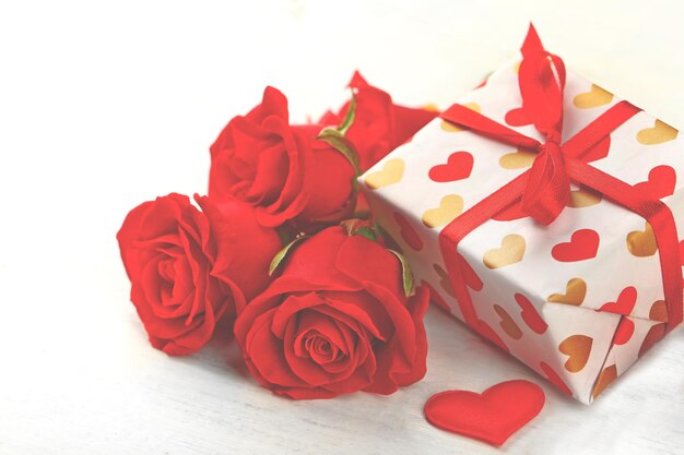 Geschenkdoos roze bloemen en decoratieve harten op lichte houten achtergrond